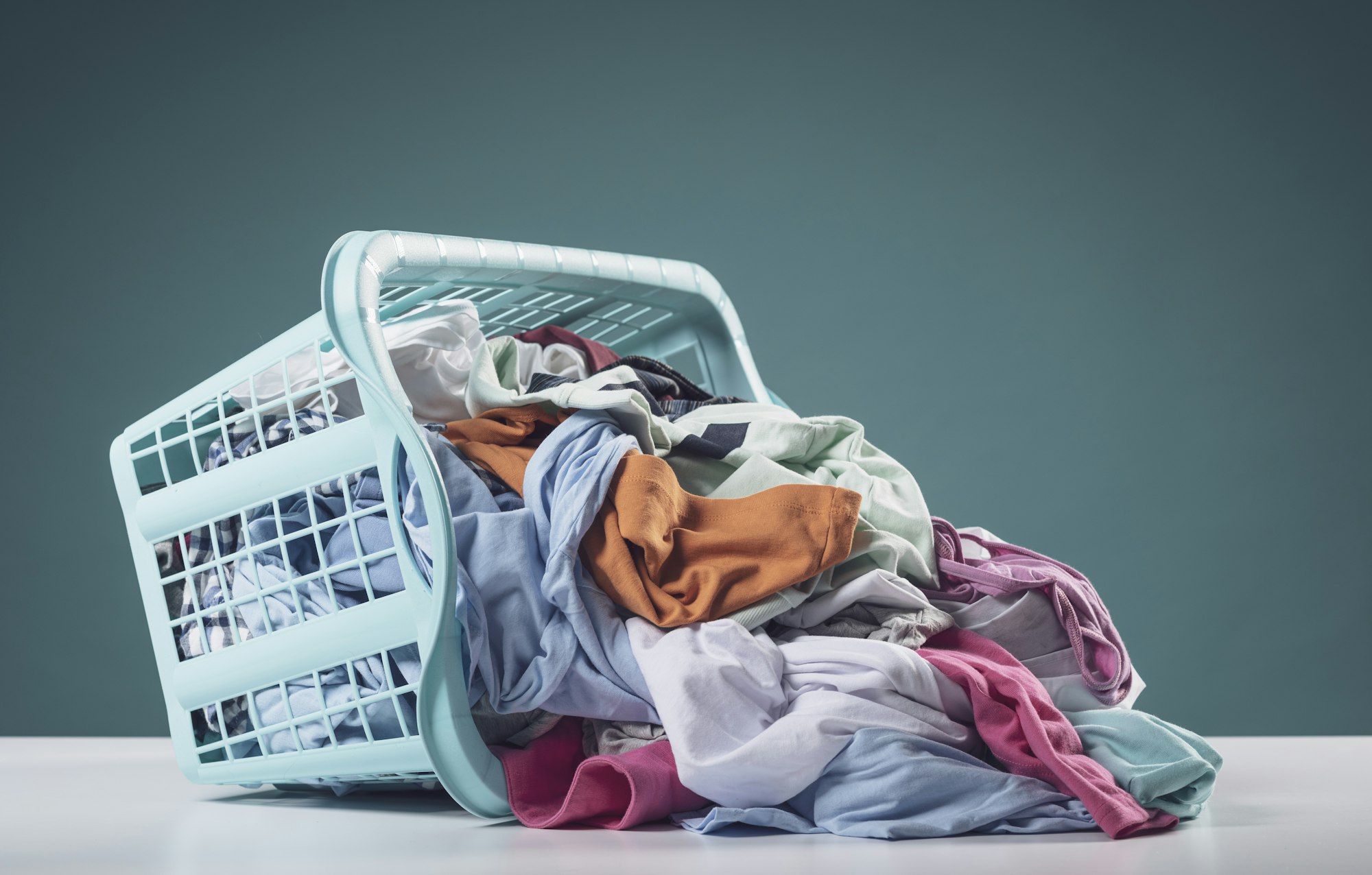 Heap of dirty clothes and laundry basket